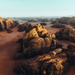 an aerial view of a desert with rocks and sand